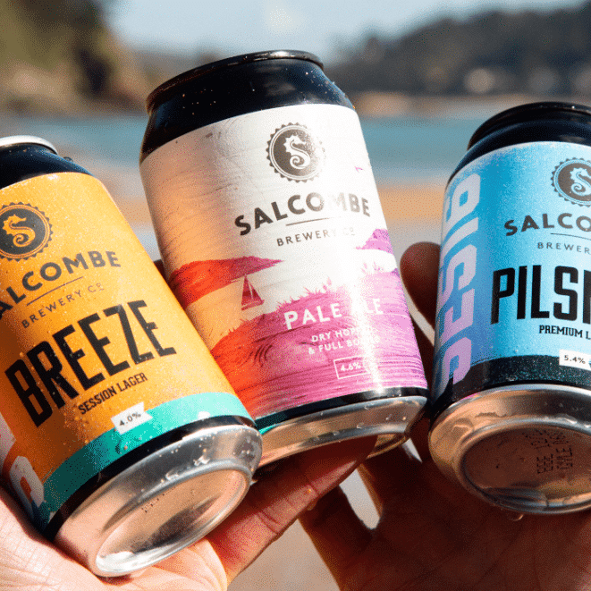 Hand holding can of Salcombe BREEZE Session Lager, Pale Ale and Pilsner.
